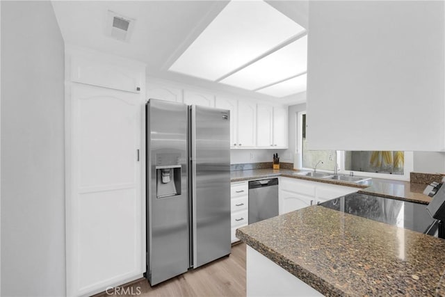 373 N Via Remo, Anaheim, CA 92806 - kitchen with appliances with stainless steel finishes, white cabinetry, dark stone countertops, and a peninsula