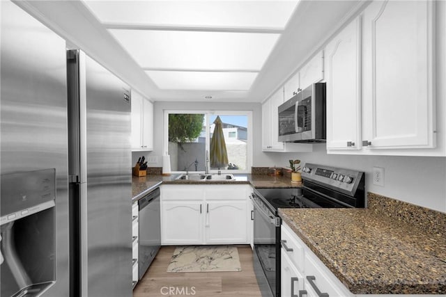373 N Via Remo, Anaheim, CA 92806 - kitchen with stainless steel appliances, white cabinetry, light wood-style floors, and dark stone countertops