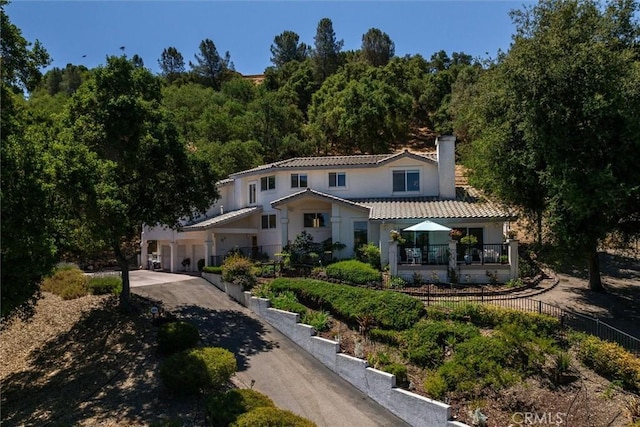 9230 Las Lomas Ave, Atascadero, CA 93422 - rear view of house with a tile roof, a chimney, driveway, stucco siding, and a forest view