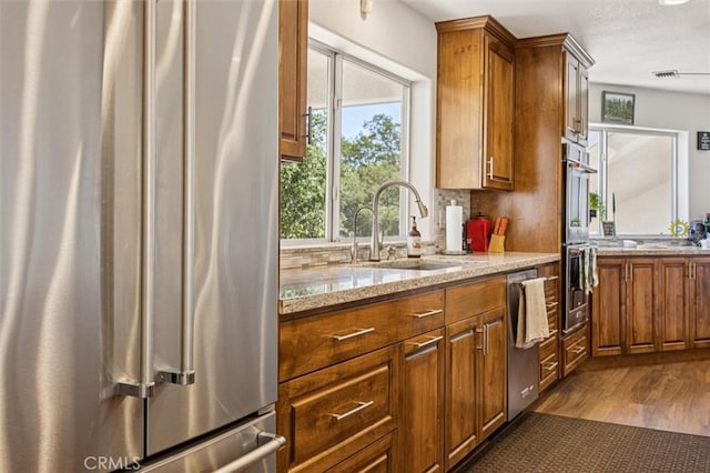 9230 Las Lomas Ave, Atascadero, CA 93422 - kitchen with stainless steel appliances, brown cabinets, light stone counters, and dark wood finished floors
