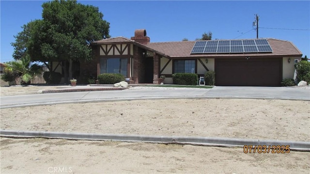 19824 Yucca Loma Rd, Apple Valley, CA 92307 - view of front facade featuring roof mounted solar panels, a chimney, a garage, a tile roof, and stucco siding