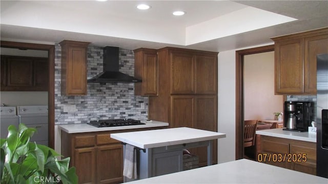 19824 Yucca Loma Rd, Apple Valley, CA 92307 - kitchen with wall chimney range hood, independent washer and dryer, black gas stovetop, backsplash, and light countertops