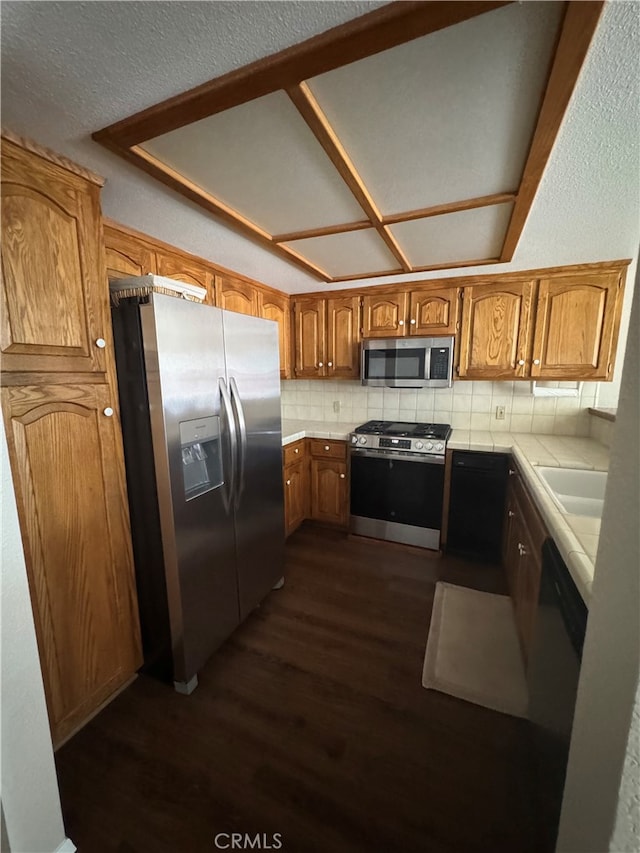 261 Spruce St Unit B, Arroyo Grande, CA 93420 - kitchen with stainless steel appliances, tile counters, dark wood-style flooring, decorative backsplash, and brown cabinets
