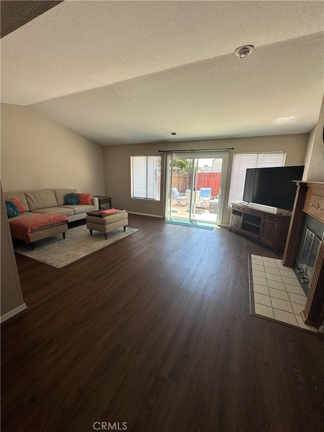 261 Spruce St Unit B, Arroyo Grande, CA 93420 - unfurnished living room with dark wood-style flooring, a textured ceiling, and a fireplace