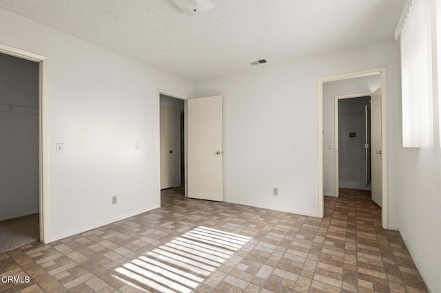 1543 Mobil Ave, Camarillo, CA 93010 - unfurnished bedroom with brick patterned flooring, a spacious closet, a closet, and a textured ceiling