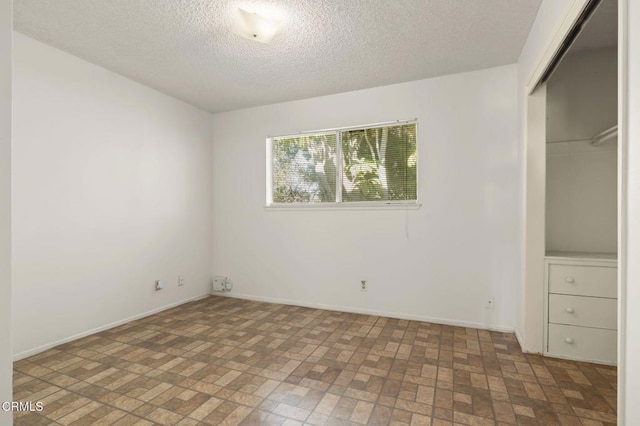 1543 Mobil Ave, Camarillo, CA 93010 - unfurnished bedroom with brick patterned floors, a textured ceiling, and a closet