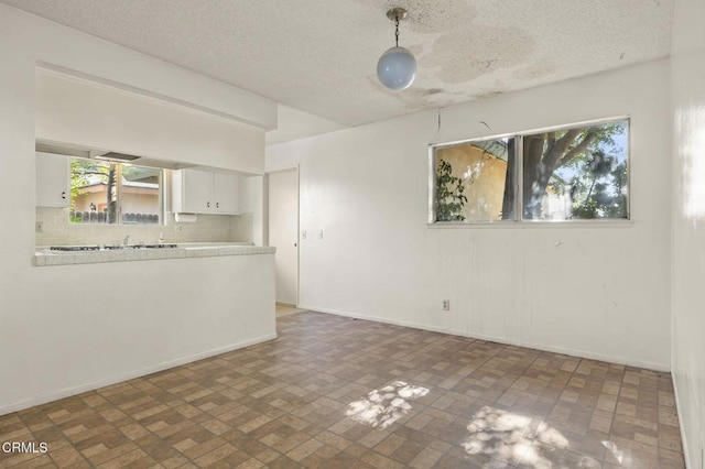 1543 Mobil Ave, Camarillo, CA 93010 - unfurnished living room with brick patterned floors and a textured ceiling