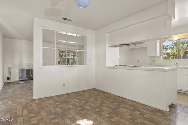 1543 Mobil Ave, Camarillo, CA 93010 - kitchen with brick patterned flooring, white cabinetry, light countertops, and tasteful backsplash