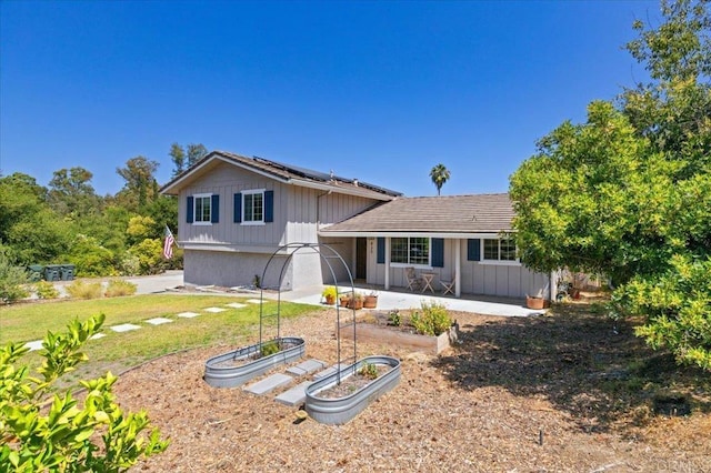 835 Minor Dr, Escondido, CA 92025 - view of front of house with a garden, solar panels, a patio, a front lawn, and board and batten siding