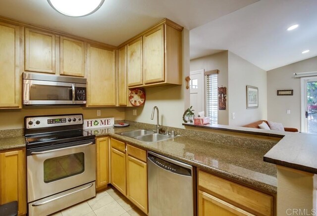 3635 Grove St Unit 268, Lemon Grove, CA 91945 - kitchen with appliances with stainless steel finishes, light brown cabinetry, lofted ceiling, light tile patterned floors, and a peninsula