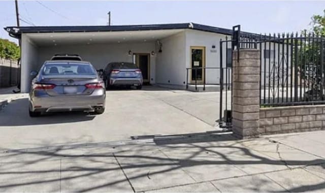 9600 Amboy Ave, Pacoima, CA 91331 - view of front facade with an attached carport, stucco siding, and driveway