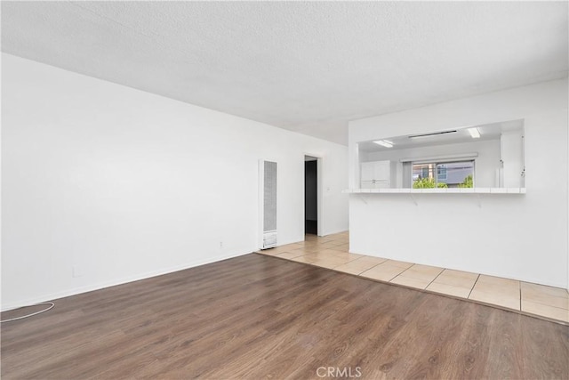 841 W 5th, San Pedro, CA 90731 - unfurnished living room featuring light wood-style floors, a heating unit, and a textured ceiling