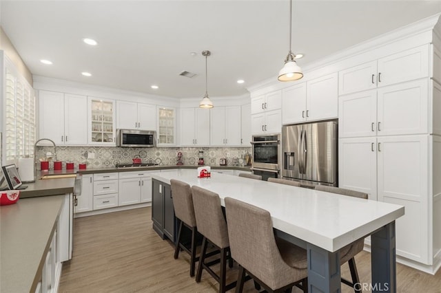 1647 Naranjo Ct, Redlands, CA 92374 - kitchen featuring appliances with stainless steel finishes, white cabinetry, tasteful backsplash, and recessed lighting