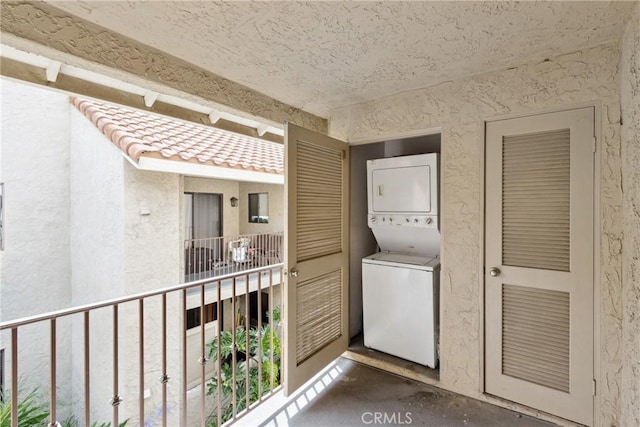 10166 Camino Ruiz Unit 32, San Diego, CA 92126 - laundry area featuring estacked washer and dryer and a textured wall