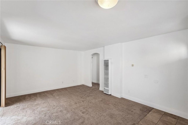 10166 Camino Ruiz Unit 32, San Diego, CA 92126 - spare room featuring a heating unit, arched walkways, and carpet floors