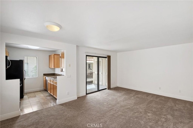 10166 Camino Ruiz Unit 32, San Diego, CA 92126 - kitchen featuring freestanding refrigerator, light colored carpet, stainless steel microwave, and open floor plan