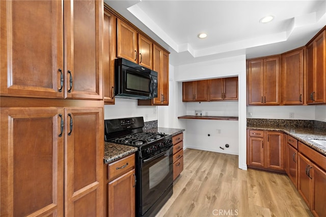 1509 N Avenida De La Estrella, San Clemente, CA 92672 - kitchen featuring black appliances, a tray ceiling, light wood-style floors, dark stone countertops, and brown cabinetry