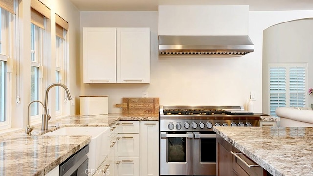 31962 Via Montura, San Juan Capistrano, CA 92675 - kitchen with wall chimney exhaust hood, stainless steel appliances, light stone counters, and white cabinets