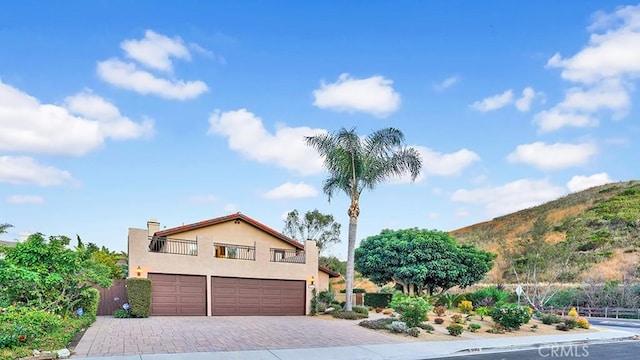 31962 Via Montura, San Juan Capistrano, CA 92675 - view of front facade with an attached garage, stucco siding, decorative driveway, a balcony, and a mountain view