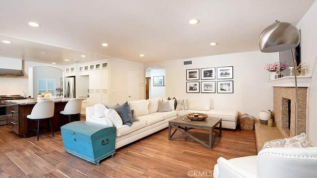 31962 Via Montura, San Juan Capistrano, CA 92675 - living area with arched walkways, recessed lighting, light wood finished floors, and a tile fireplace