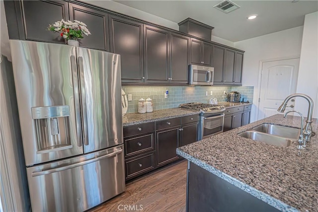 24270 Verdugo Cir, Valencia, CA 91354 - kitchen with stainless steel appliances, stone countertops, decorative backsplash, dark wood finished floors, and dark brown cabinetry