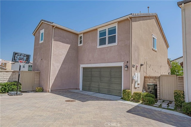 24270 Verdugo Cir, Valencia, CA 91354 - rear view of property with stucco siding, an attached garage, and decorative driveway