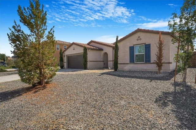 12956 9th Ave, Victorville, CA 92395 - mediterranean / spanish-style home with stucco siding, an attached garage, concrete driveway, and a tiled roof