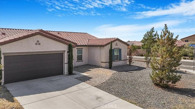 12956 9th Ave, Victorville, CA 92395 - mediterranean / spanish house with stucco siding, concrete driveway, an attached garage, and a tiled roof