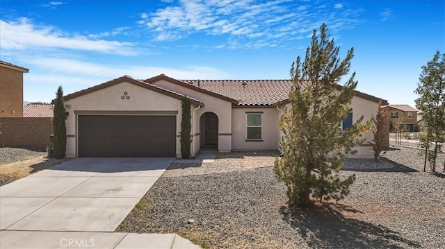 12956 9th Ave, Victorville, CA 92395 - mediterranean / spanish home featuring stucco siding, a garage, a tile roof, and concrete driveway