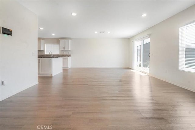 12956 9th Ave, Victorville, CA 92395 - unfurnished living room with light wood-style flooring and recessed lighting
