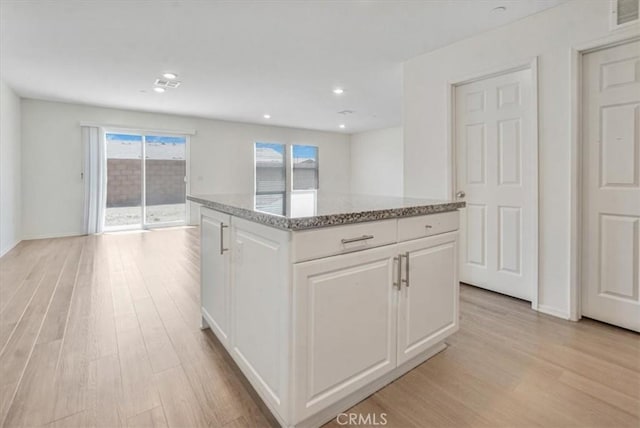 12956 9th Ave, Victorville, CA 92395 - kitchen featuring light wood-style flooring, light stone counters, white cabinets, a center island, and recessed lighting