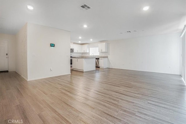 12956 9th Ave, Victorville, CA 92395 - unfurnished living room with light wood-type flooring and recessed lighting
