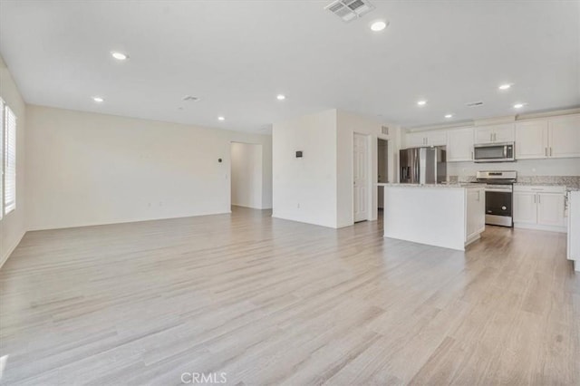 12956 9th Ave, Victorville, CA 92395 - unfurnished living room with recessed lighting and light wood-style flooring