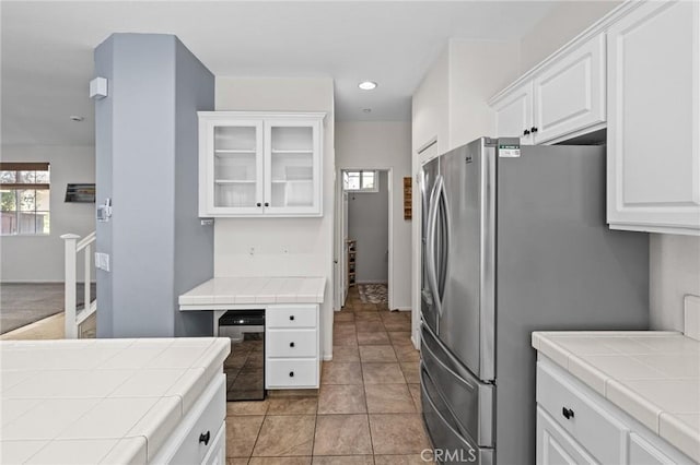 11317 Riverleaf Dr, Riverside, CA 92505 - kitchen featuring tile countertops, freestanding refrigerator, white cabinetry, beverage cooler, and glass insert cabinets