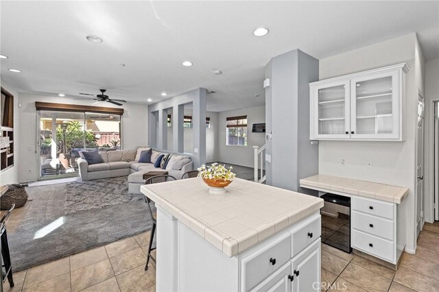 11317 Riverleaf Dr, Riverside, CA 92505 - kitchen with tile counters, light tile patterned floors, white cabinetry, recessed lighting, and glass insert cabinets