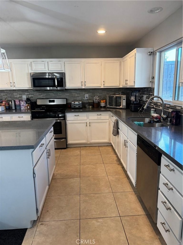 32555 Via Perales, Temecula, CA 92592 - kitchen with stainless steel appliances, dark countertops, backsplash, white cabinets, and recessed lighting