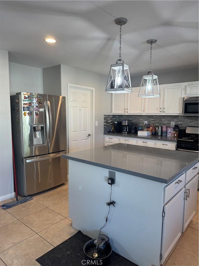32555 Via Perales, Temecula, CA 92592 - kitchen featuring stainless steel appliances, dark countertops, white cabinetry, a kitchen island, and light tile patterned floors