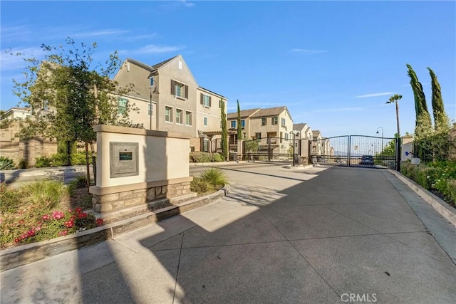 2123 Crescent Moon, Upland, CA 91786 - view of concrete road with a gate, a residential view, curbs, and a gated entry
