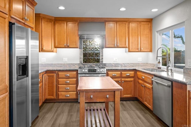 11052 Madrigal St, San Diego, CA 92129 - kitchen featuring appliances with stainless steel finishes, wood finished floors, brown cabinetry, light stone countertops, and recessed lighting