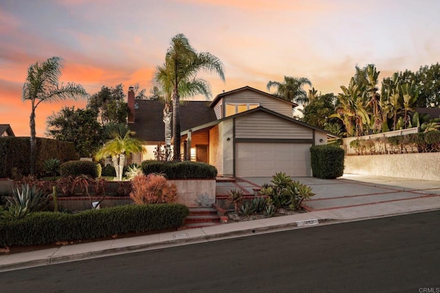 11052 Madrigal St, San Diego, CA 92129 - view of front of house featuring concrete driveway, a garage, and a chimney