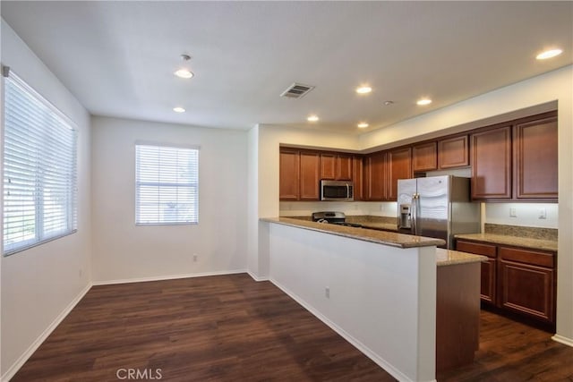 44939 Bellflower Ln Unit 118, Temecula, CA 92592 - kitchen with stainless steel appliances, dark wood-type flooring, a peninsula, recessed lighting, and light stone counters