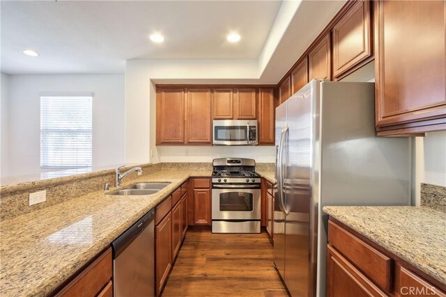 44939 Bellflower Ln Unit 118, Temecula, CA 92592 - kitchen with stainless steel appliances, light stone countertops, dark wood finished floors, recessed lighting, and brown cabinetry
