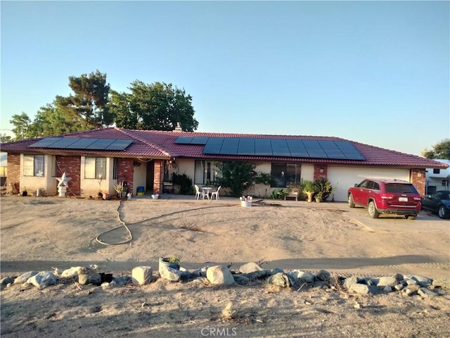 2390 Trinity Rd, Pinon Hills, CA 92372 - ranch-style house with a tile roof, an attached garage, and solar panels