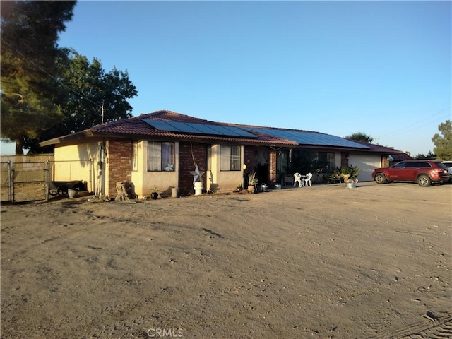 2390 Trinity Rd, Pinon Hills, CA 92372 - ranch-style house with roof mounted solar panels, a garage, and brick siding