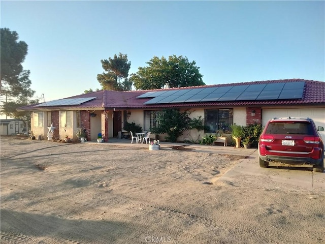 2390 Trinity Rd, Pinon Hills, CA 92372 - ranch-style house with an attached garage, roof mounted solar panels, stucco siding, concrete driveway, and a tiled roof