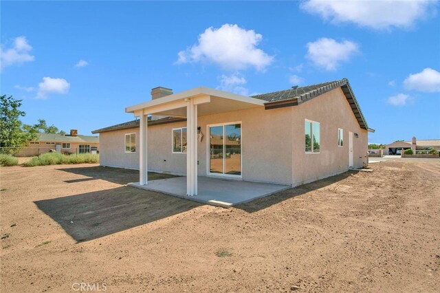 10533 Mohawk Rd, Apple Valley, CA 92308 - rear view of house featuring a patio area, a chimney, and stucco siding
