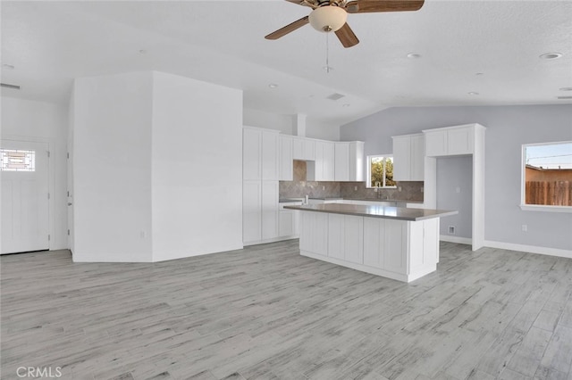 10533 Mohawk Rd, Apple Valley, CA 92308 - kitchen with lofted ceiling, white cabinets, decorative backsplash, a ceiling fan, and plenty of natural light