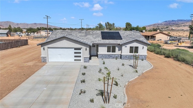 10533 Mohawk Rd, Apple Valley, CA 92308 - ranch-style house featuring stone siding, stucco siding, a garage, concrete driveway, and a mountain view