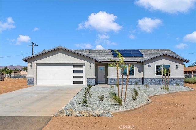 10533 Mohawk Rd, Apple Valley, CA 92308 - single story home with stone siding, roof mounted solar panels, a garage, and stucco siding