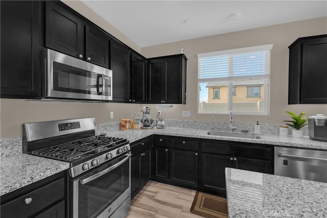 1511 Asteroid Way, Beaumont, CA 92223 - kitchen with stainless steel appliances, dark cabinets, light wood-style floors, and light stone countertops